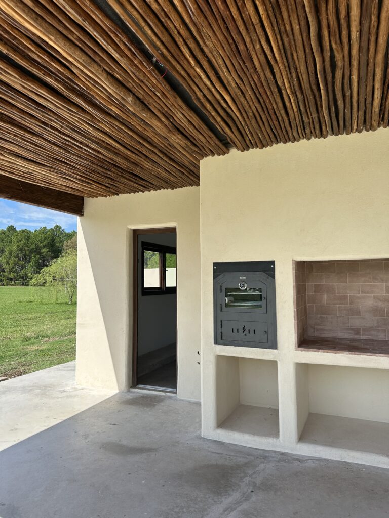 galeria con estilo mediterraneo, parrilla y horno a leña