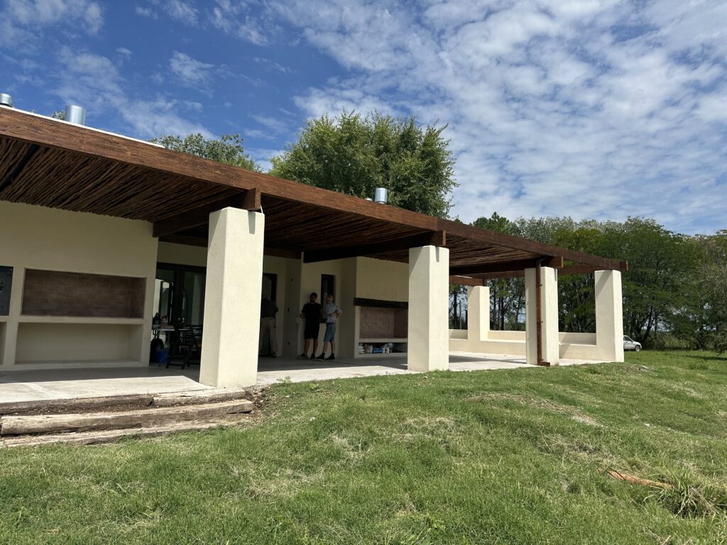 Exterior con revestimientos de tarquini y vigas añejadas
