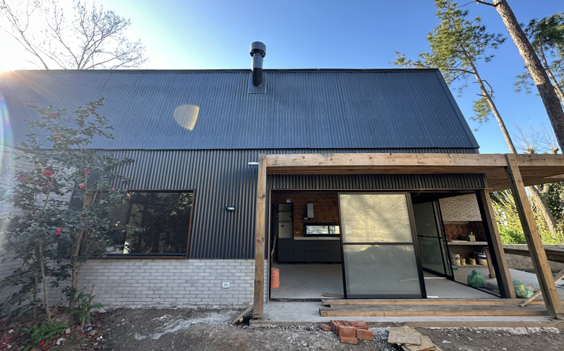 Casa con entrepiso y lucarna revestida en chapa y tejas