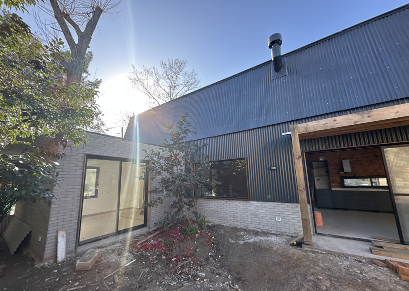 Casa con entrepiso y lucarna revestida en chapa y tejas