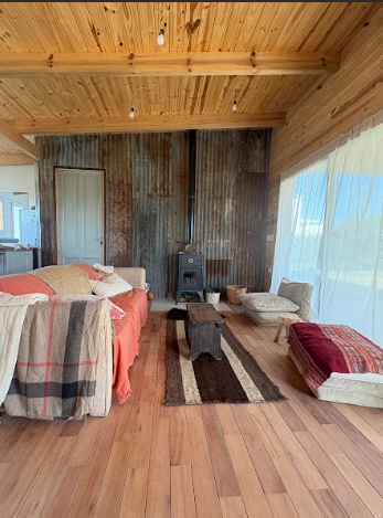 living comedor con revestimiento de madera y chapa oxidada