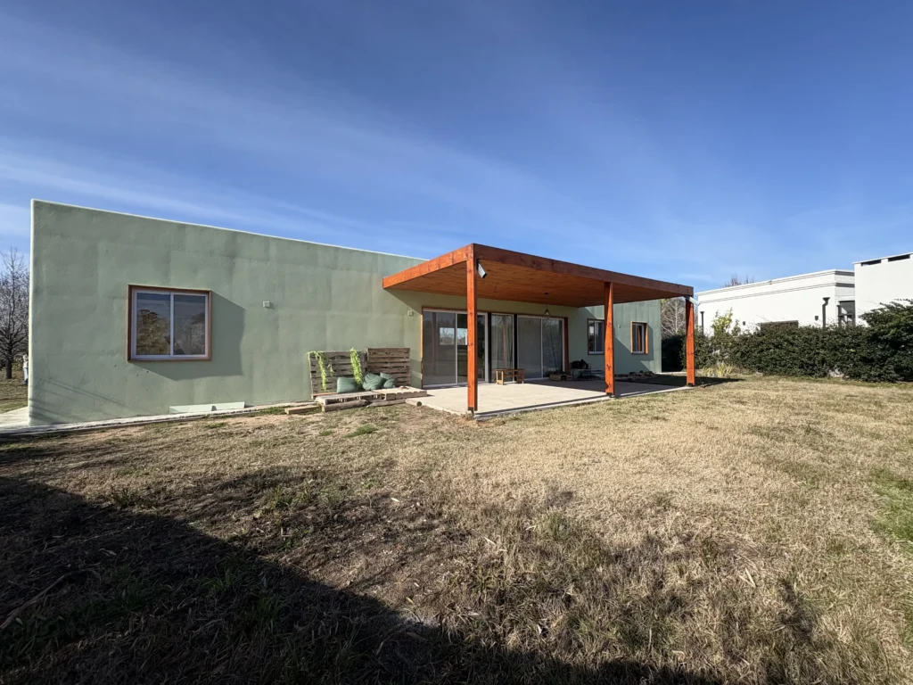 Casa con terminaciones rústicas y revestimiento de tarquini verde