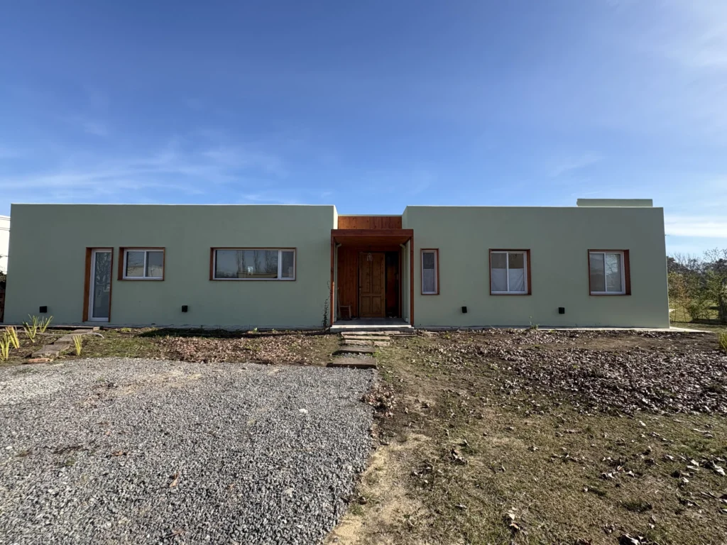 Casa con terminaciones rústicas y revestimiento de tarquini verde