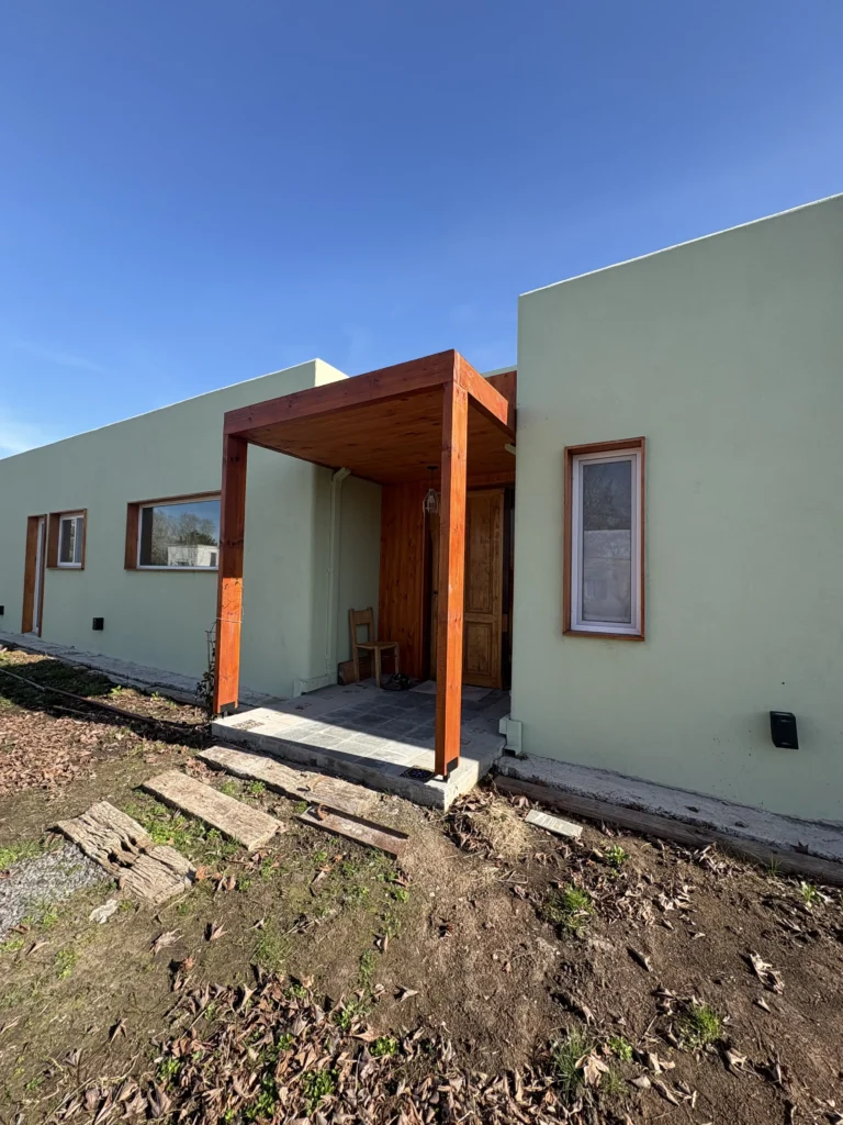 Casa con terminaciones rústicas y revestimiento de tarquini verde