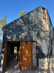 Casa con entrepiso y lucarna revestida en chapa y tejas