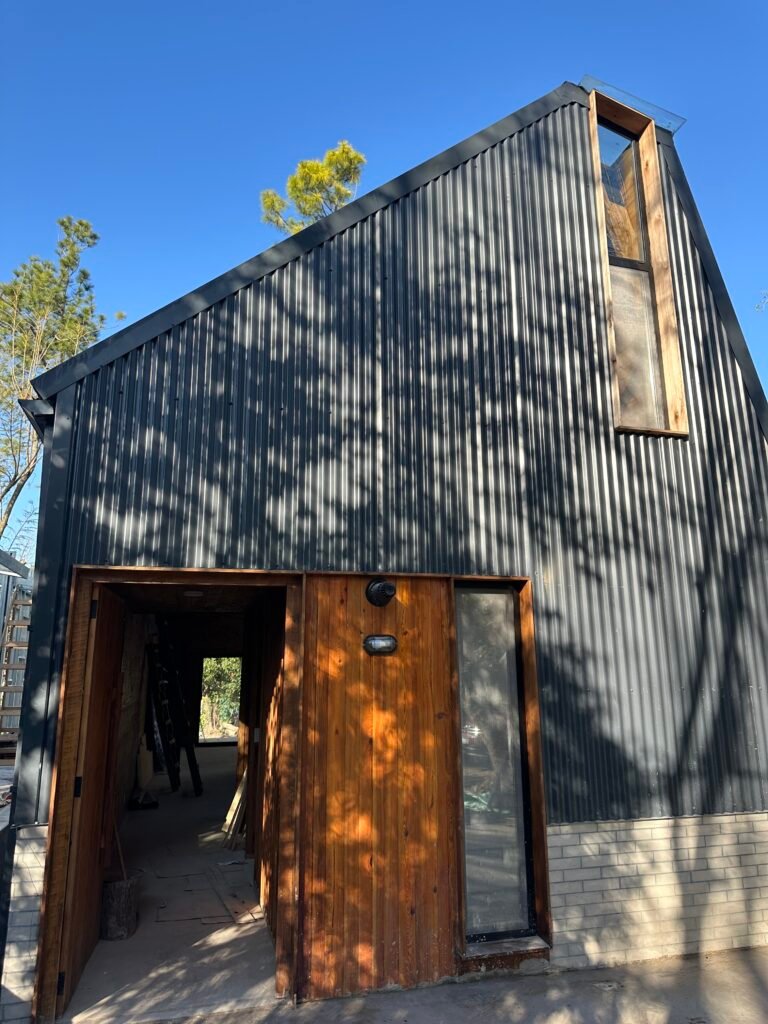 Casa con entrepiso y lucarna revestida en chapa y tejas